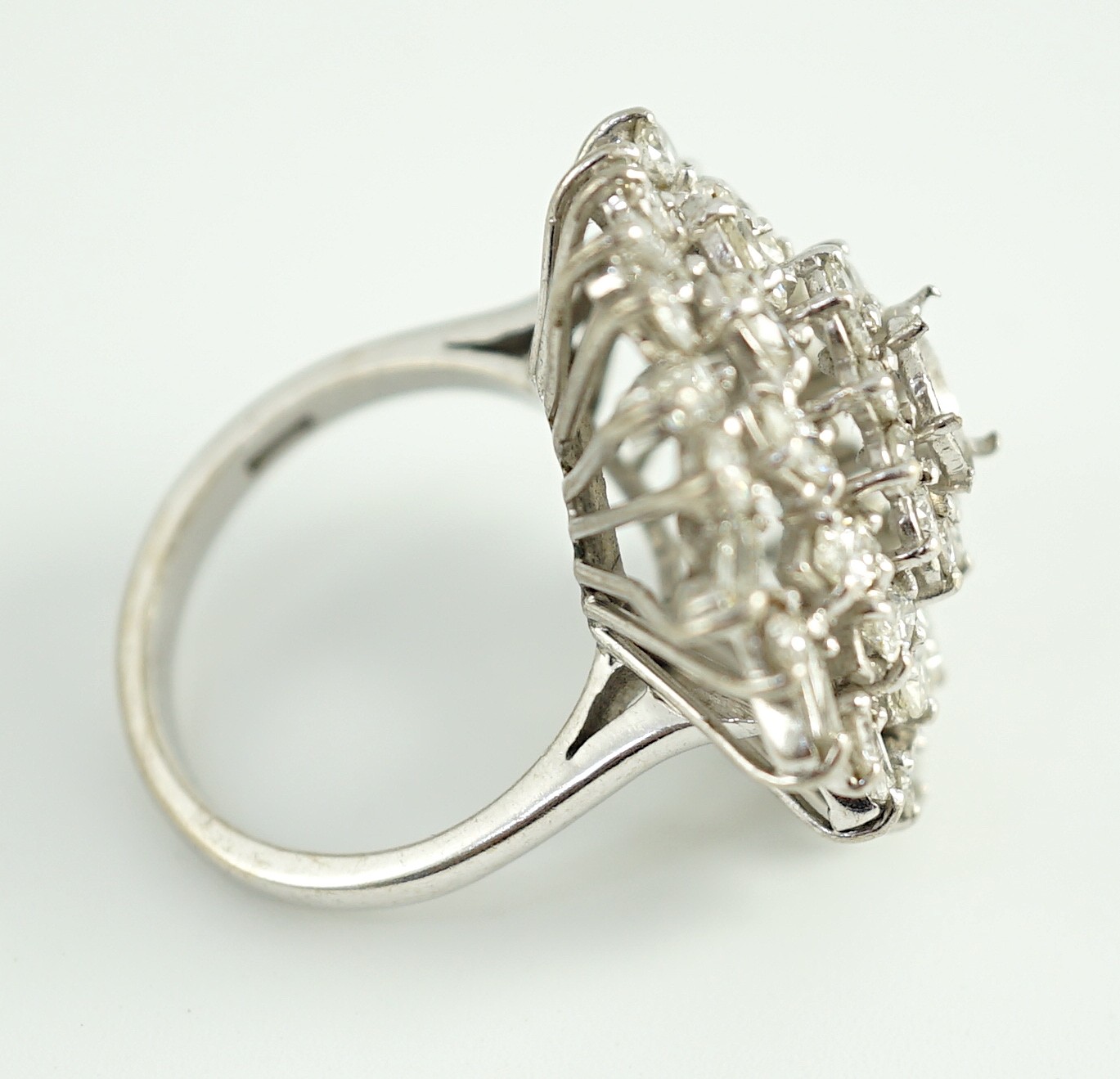 A modern 18ct white gold, ruby and round, baguette and marquise cut diamond cluster set dress ring